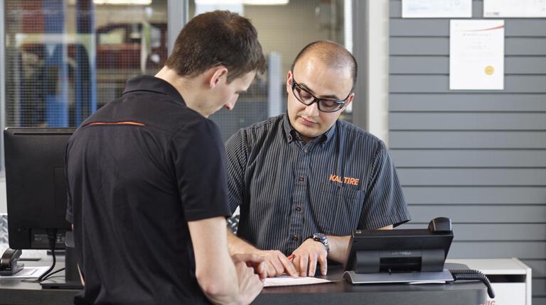 Team member going over rotor and brake replacement cost with customer