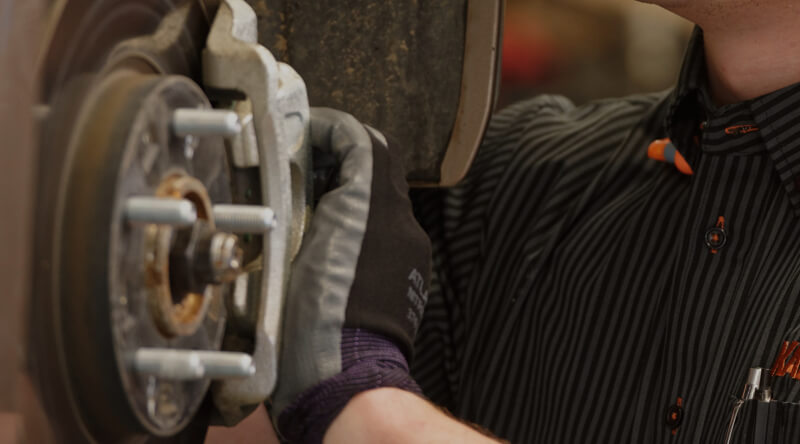 Kal Tire team member working on brakes