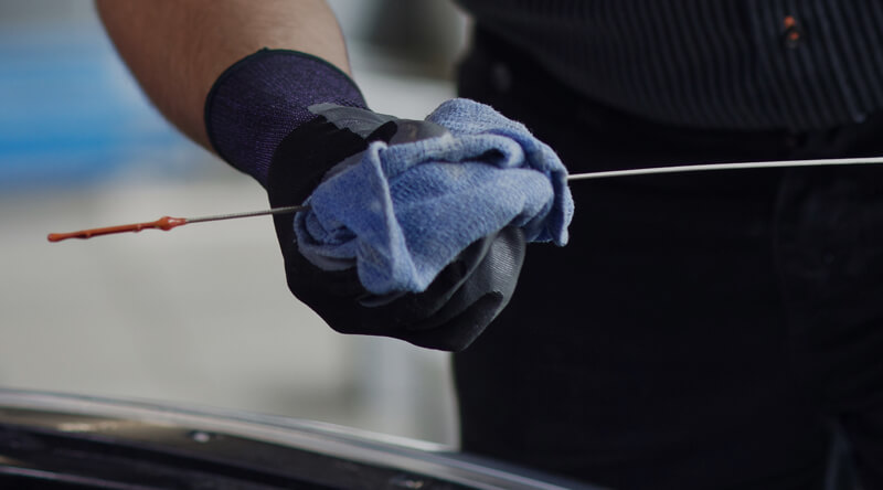 Kal Tire team member checking oil