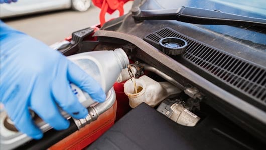 Kal Tire team member adding brake fluid