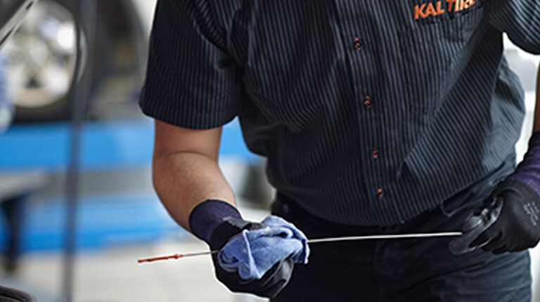 Kal Tire team member checking oil